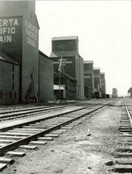 Vintage black-and-white photo of the row of grain elevators along the railway tracks in Dawson Creek