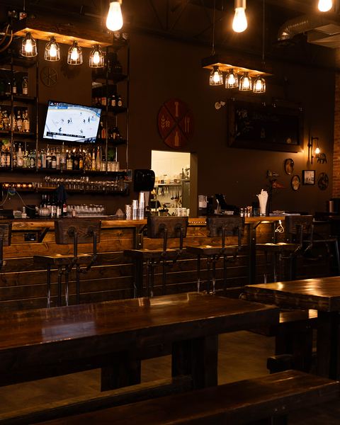 The Post & Row taproom bar with its stools, back bar and TVs
